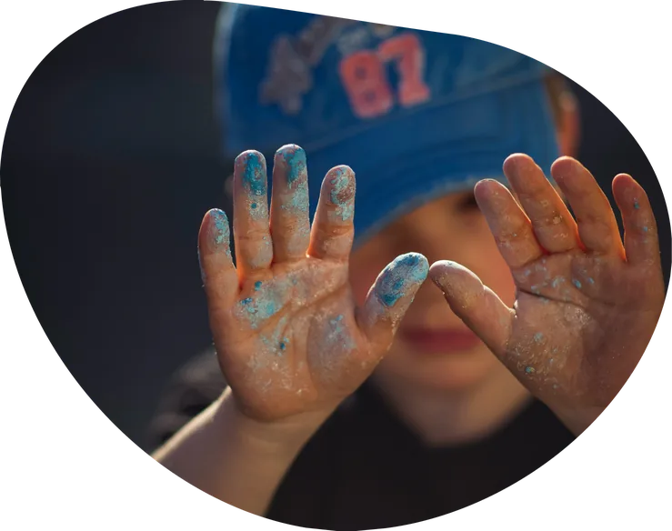 Child showing hands covered in paint